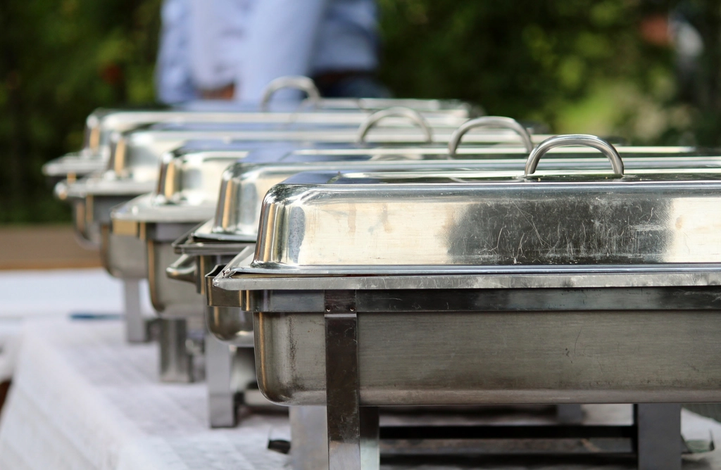 A row of chafing dishes set up for a buffet